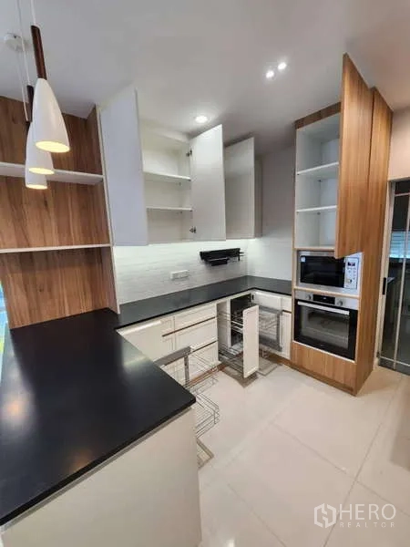Detached House for rent in Sathon, Bangkok - Kitchen storage solutions with open cabinets and pull-out wire baskets.
