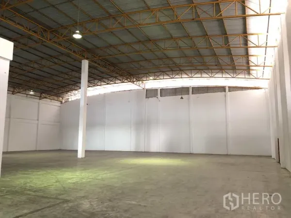 Warehouse for rent in Phra Nakhon Si Ayutthaya - Spacious warehouse interior with high steel truss roof, white walls and polished concrete floor.