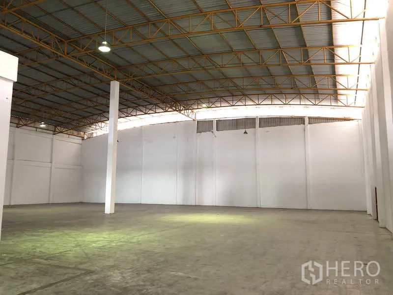 Warehouse for rent in Phra Nakhon Si Ayutthaya - Spacious warehouse interior with high steel truss roof, white walls and polished concrete floor.