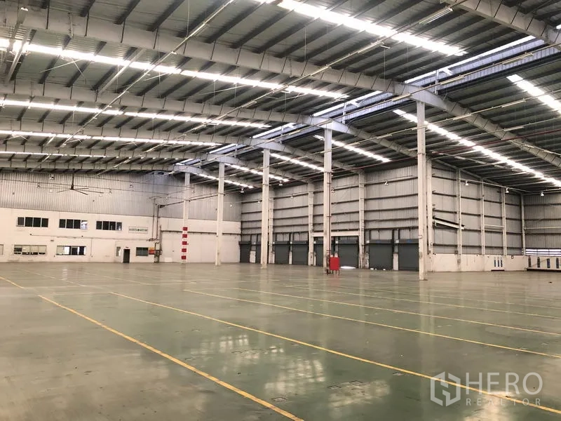 Factory for rent in Phra Nakhon Si Ayutthaya - Open production area with high clearance, steel columns and an office section to the side.