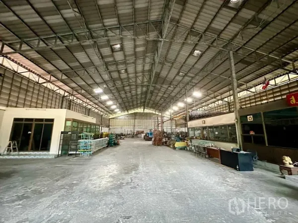 Warehouse for rent in Sai Noi, Nonthaburi - Spacious high-ceiling warehouse interior with steel truss roof, skylights and internal office rooms.