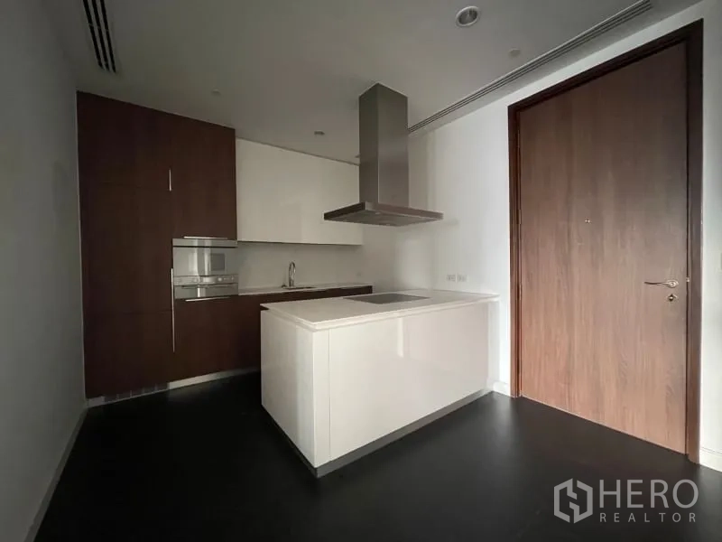 Condominium for rent or sale in Pathum Wan, Bangkok - Contemporary kitchen with island, induction cooktop, range hood and built-in oven and cabinetry.