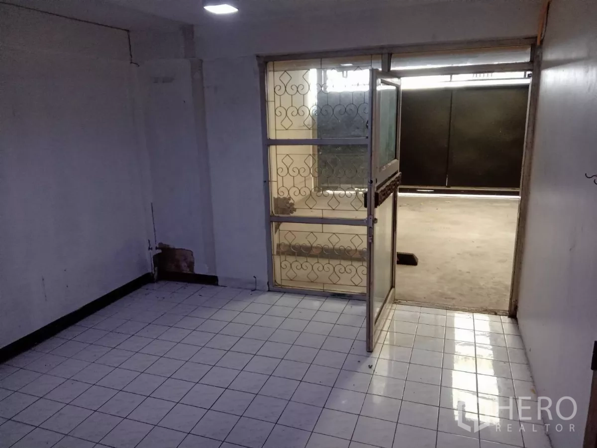 Detached House for rent in Phaya Thai, Bangkok - Small tiled room opening to a covered carport through a metal gate door.