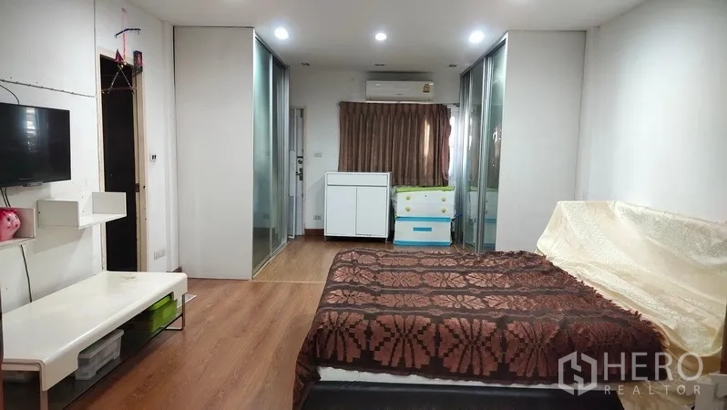 联排别墅 出租在Watthana, Bangkok - 主卧另一角，壁挂电视、空调与遮光窗帘。