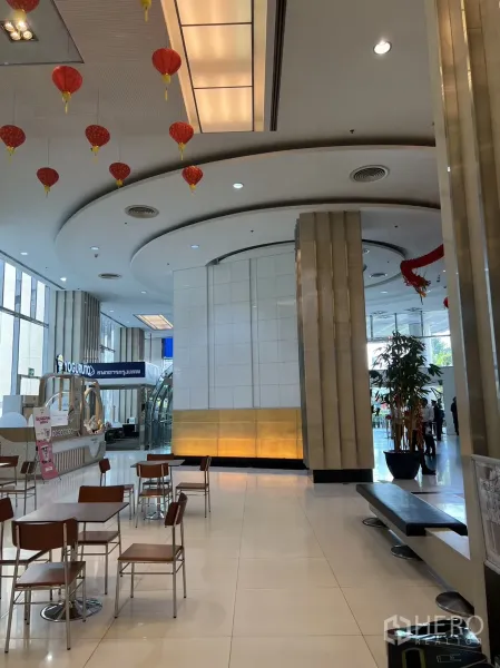 Retail Space for rent in Khlong Toei, Bangkok - Spacious mall concourse with curved ceiling details, lantern decor, a cafe kiosk and seating near a glass entrance.