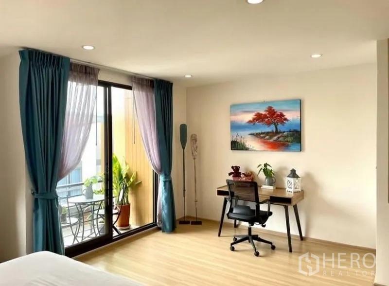 Townhouse for rent in Suan Luang, Bangkok - Primary bedroom workstation with balcony and garden views.