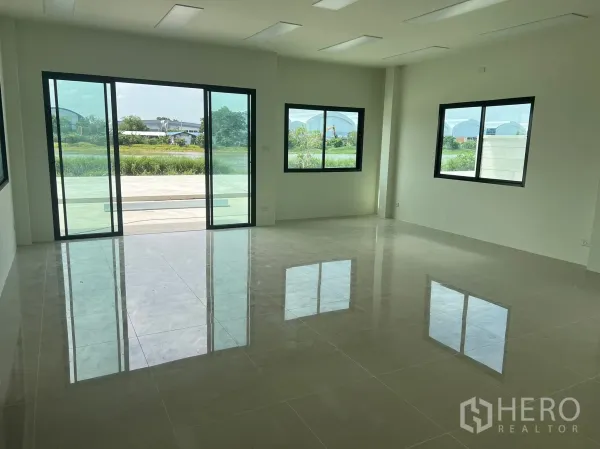 工厂 出租在Bang Phli, Samut Prakan - 一层明亮办公区，亮面地砖，推拉玻璃门，绿色景观视野。