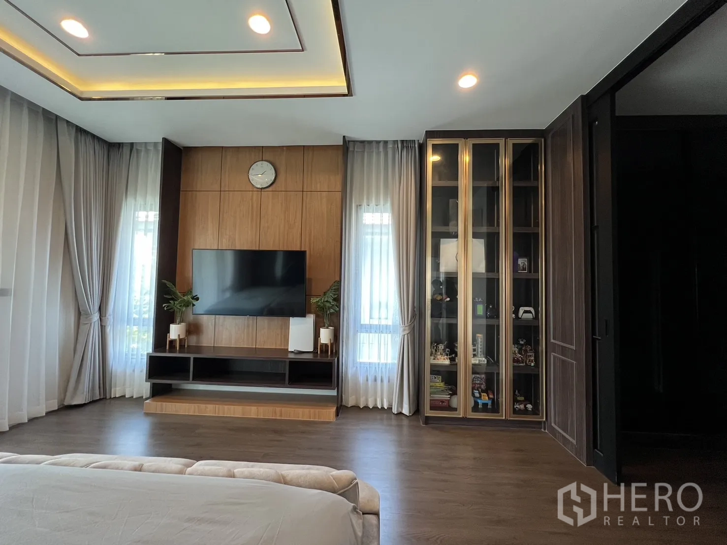 Detached House for rent or sale in Bang Kapi, Bangkok - Master bedroom front view with display cabinets and floor-to-ceiling curtains.