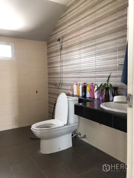 Detached House for sale in Lam Luk Ka, Pathum Thani - Bathroom with striped feature wall, toilet and vanity.