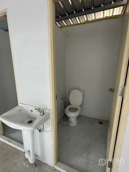 Warehouse for rent in Bang Bua Thong, Nonthaburi - Clean restroom with toilet and sink inside the warehouse facility.