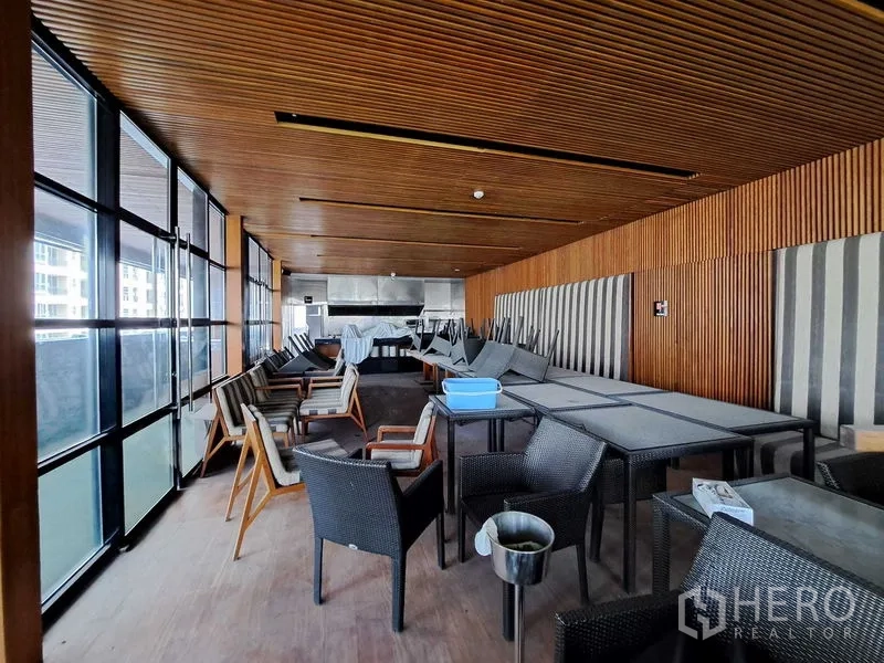 Retail Space for rent in Khlong Toei, Bangkok - Wood-lined indoor dining hall with floor-to-ceiling glass and stacked tables and chairs in a retail unit.