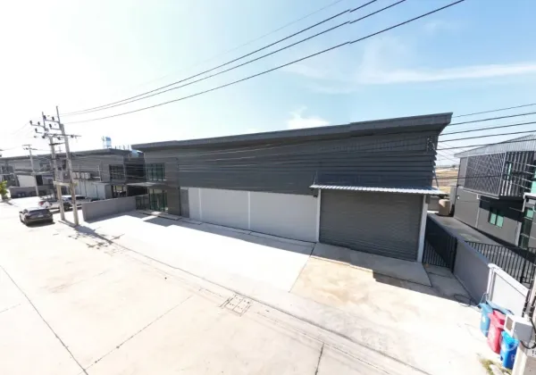 Factory for rent in Bang Bo, Samut Prakan - Street view of the factory frontage with glass office, roller shutter and spacious driveway.