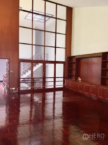 Townhouse for rent in Watthana, Bangkok - Grand room with high ceilings, built-in cabinetry and parquet wood flooring.