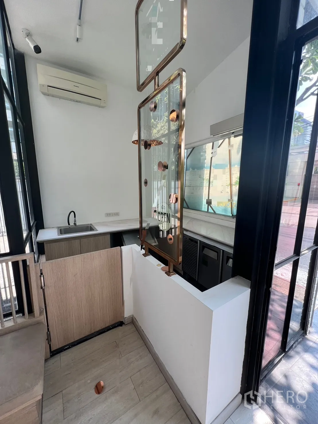 Retail Space for rent in Pathum Wan, Bangkok - Compact service counter with sink and display frame beside large windows and air conditioning.
