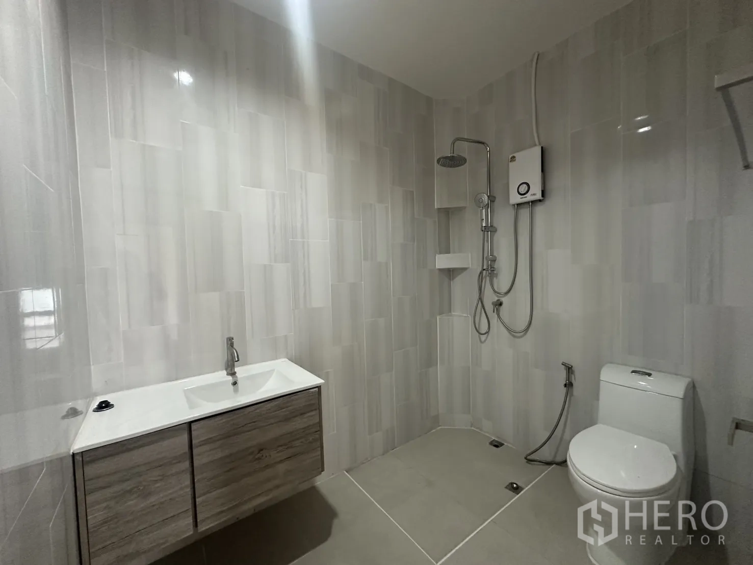 Home Office for rent in Khlong Toei, Bangkok - Bathroom with gray wall tiles, rain shower and floating vanity.
