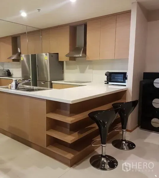 Condominium for rent or sale in Khlong Toei, Bangkok - Fully fitted kitchen with island counter, bar stools and built-in cabinetry.