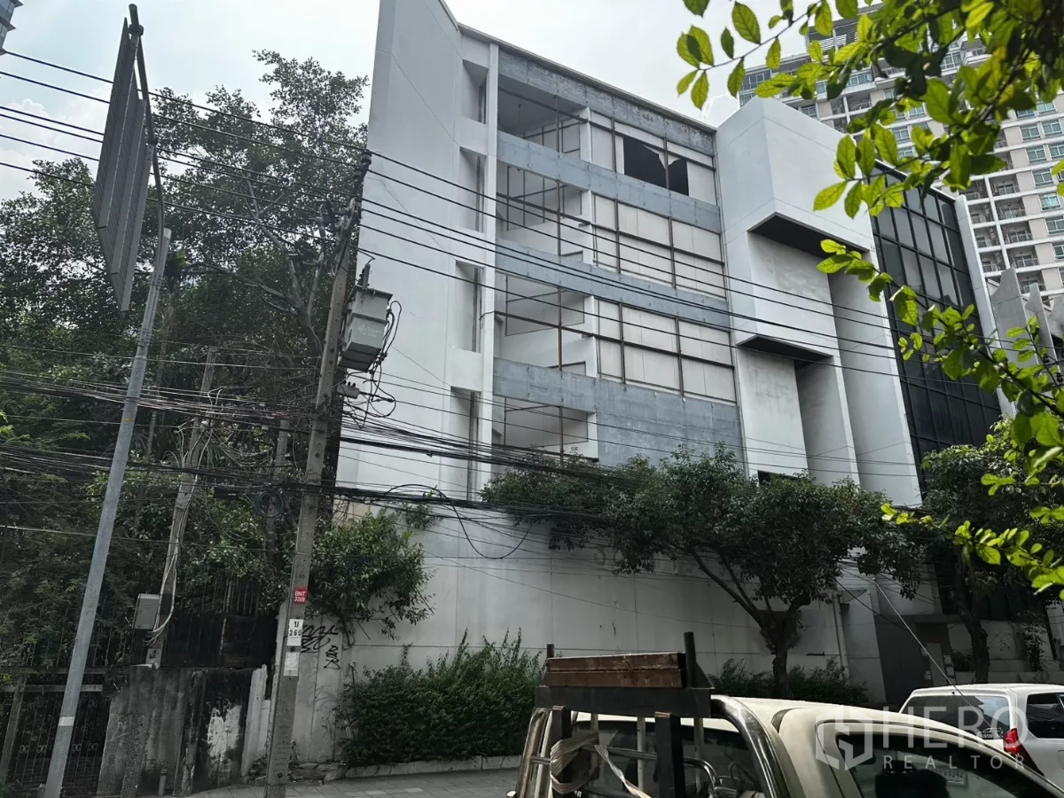 Retail Space for rent in Bang Na, Bangkok - Multi-storey commercial building with wide street frontage on Sukhumvit Road in Bang Na, framed by trees and power lines.