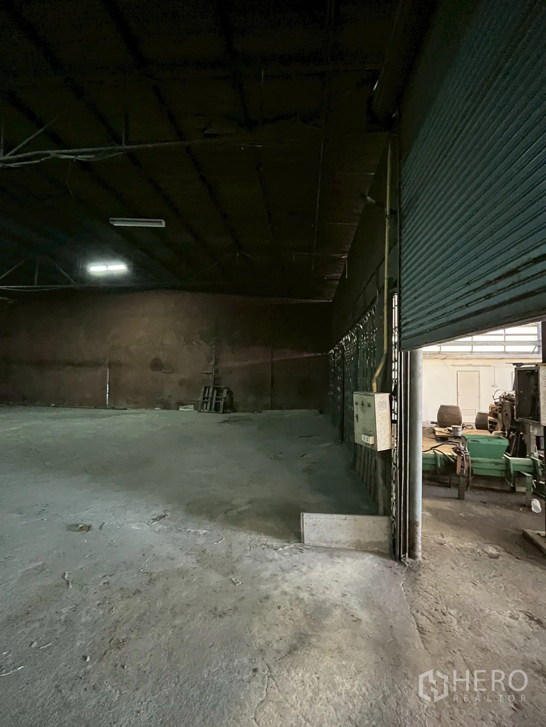 Factory for rent in Phra Pradaeng, Samut Prakan - Deep storage area with steel beams and overhead lighting.