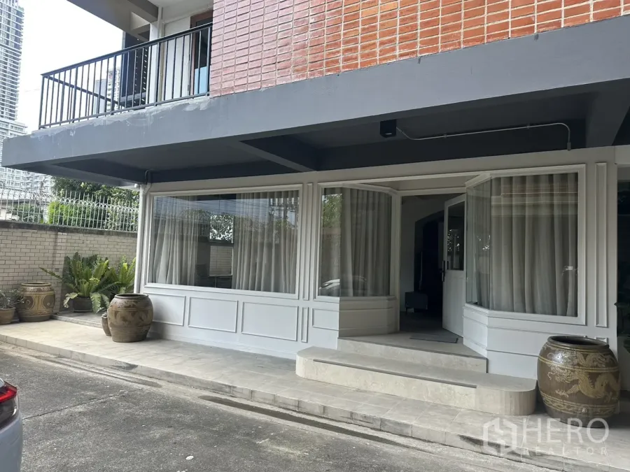 零售空间 for rent in Watthana, Bangkok - 临街外立面设大幅落地窗、入口台阶与大型陶缸。