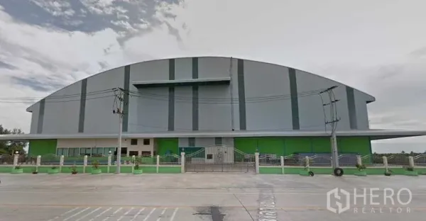 Factory for rent in Sai Noi, Nonthaburi - Front elevation of a large arched‑roof factory with secure gate in Sai Noi, Nonthaburi.