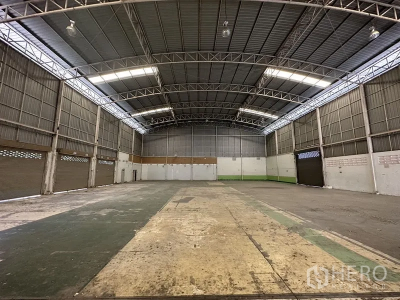 Factory for rent in Phra Nakhon Si Ayutthaya - Rear view across the clear-span warehouse with high clearance, ventilated walls and multiple shutters.