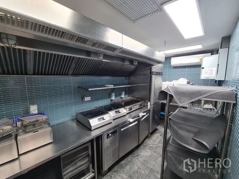 Retail Space for rent in Bang Rak, Bangkok - Stainless steel commercial kitchen with exhaust hood, fryers and prep counters.