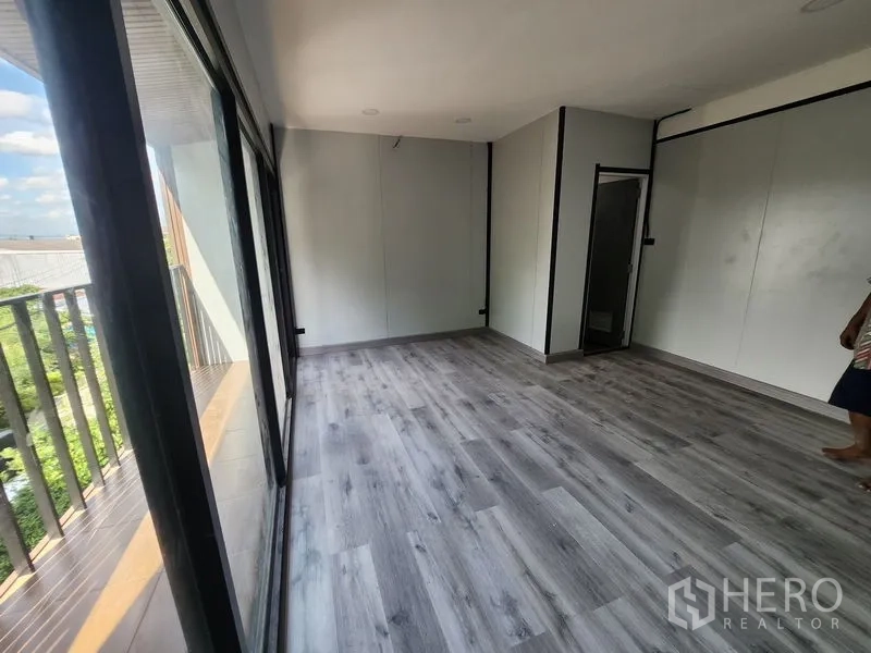 Warehouse for rent in Lam Luk Ka, Pathum Thani - Upper-floor office with grey wood-look flooring, glass wall and an internal restroom.