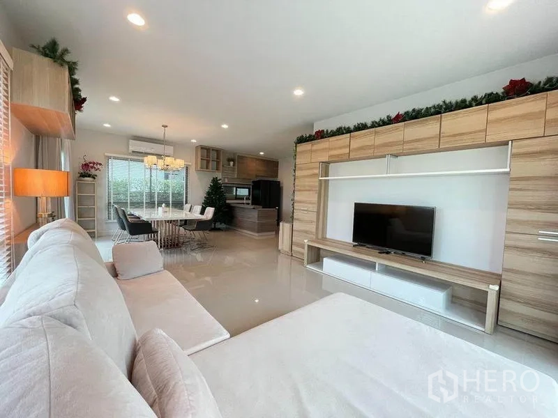 Detached House for sale in Pak Kret, Nonthaburi - Bright living area with built-in TV wall, open kitchen and dining zones.