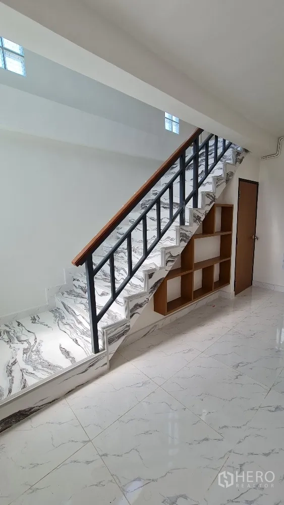 独栋房屋 for rent in Lat Phrao, Bangkok - 特色楼梯，大理石纹踏步、黑色扶手与楼梯下储物格。