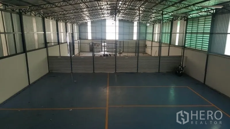 Warehouse for rent in Suan Luang, Bangkok - Mezzanine view over open warehouse floor with partitioned storage area and high roof.