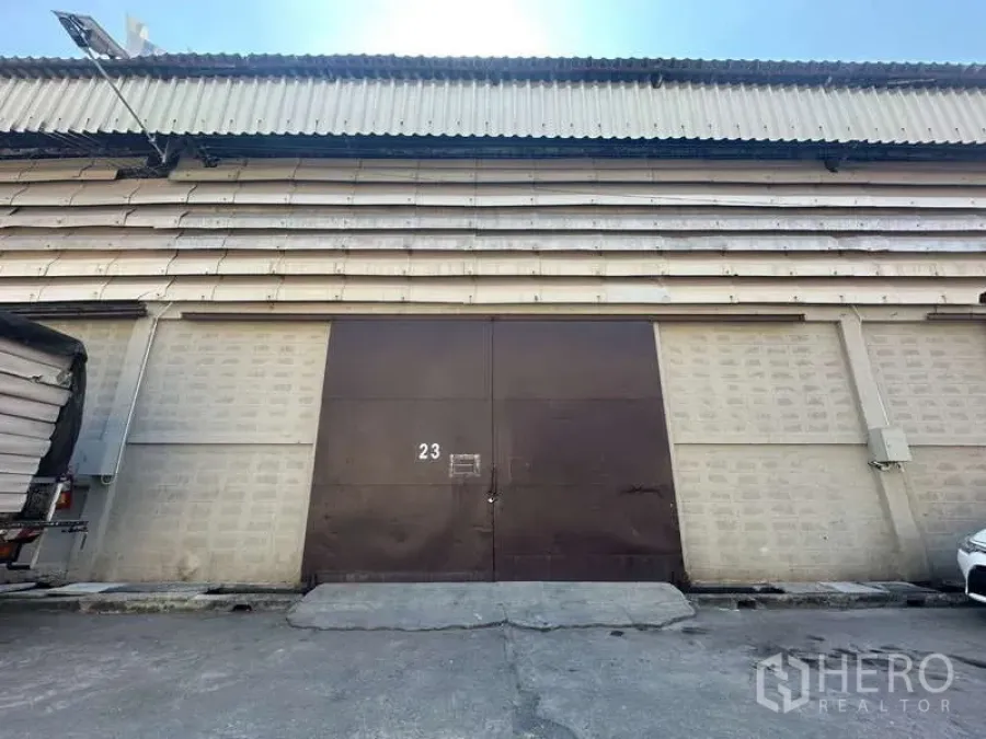 Warehouse for rent in Sathon, Bangkok - Street-facing warehouse facade with large steel double doors and corrugated roof in Sathon, Bangkok.