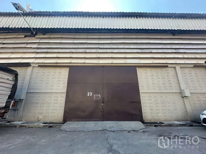 Warehouse for rent in Sathon, Bangkok - Street-facing warehouse facade with large steel double doors and corrugated roof in Sathon, Bangkok.