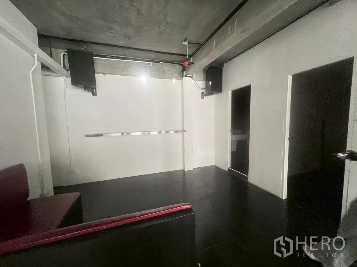 Shophouse for rent in Watthana, Bangkok - Room with black tile flooring, exposed ceiling services, and a small bar counter.