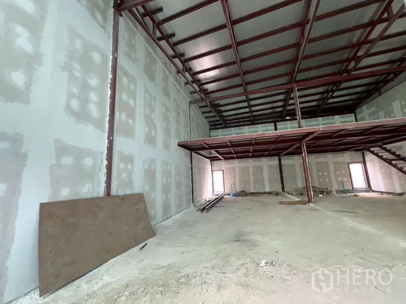 Retail Space for rent in Watthana, Bangkok - Unfinished retail space showing high ceiling, mezzanine platform and concrete floor.