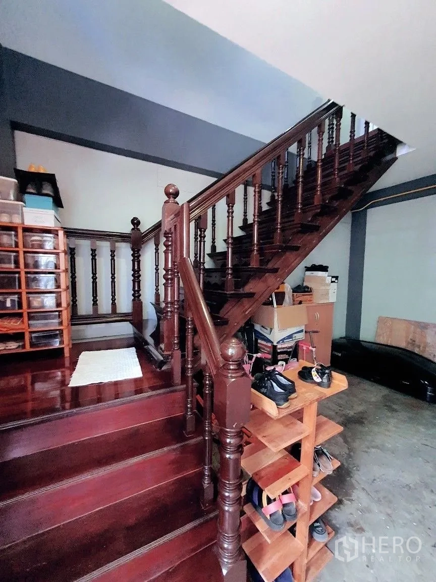 Warehouse for rent in Lam Luk Ka, Pathum Thani - Close-up of a dark wooden staircase and shoe rack inside the building.