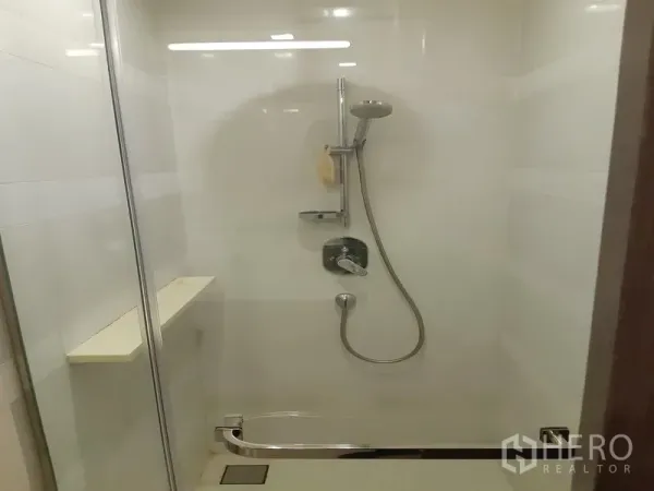 Condominium for sale in Khlong Toei, Bangkok - Glass-enclosed shower with handheld showerhead and built-in shelf.