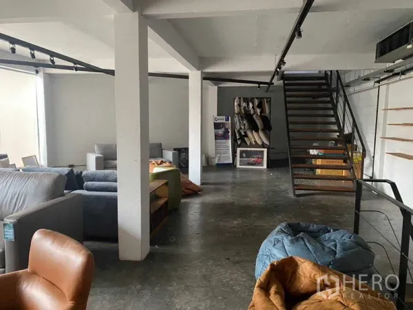 Retail Space for rent in Bang Na, Bangkok - Open-plan retail floor with concrete floors, white columns and a metal staircase