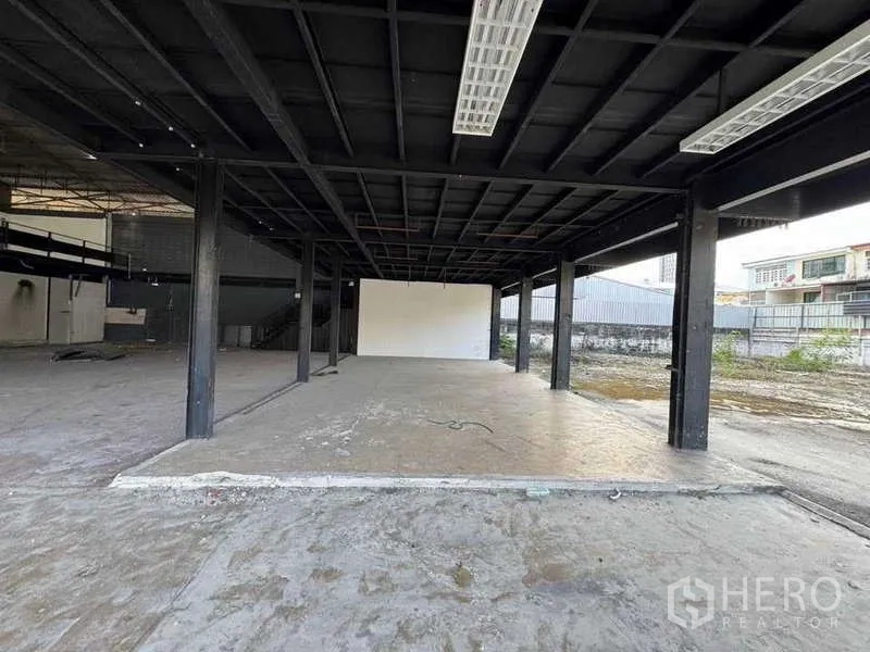 Warehouse for rent in Phra Khanong, Bangkok - Ground-level covered zone beneath the mezzanine for loading or workspace opening to a yard.