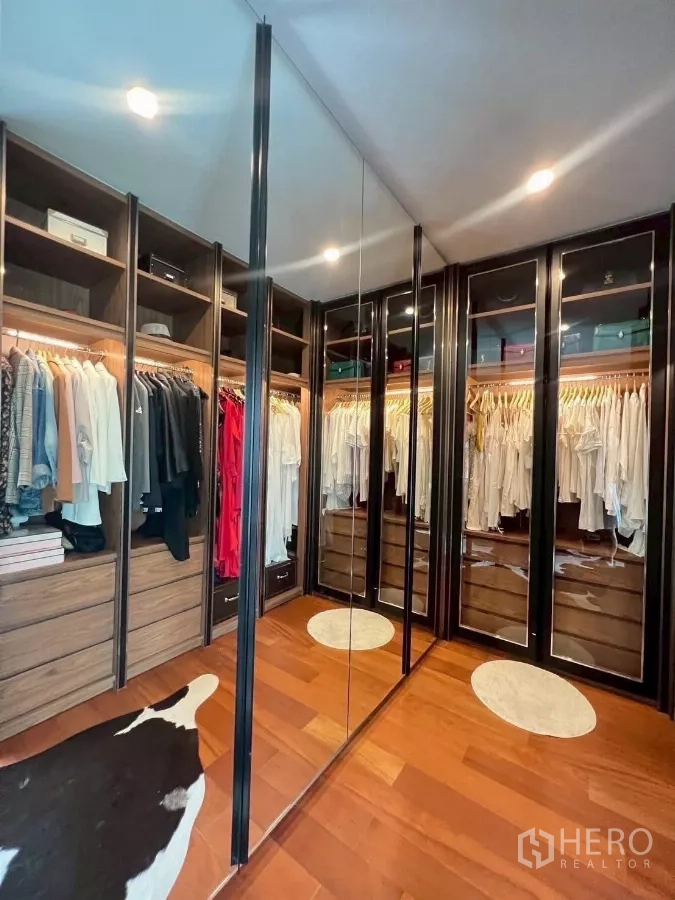 Detached House for rent or sale in Prawet, Bangkok - Expansive wardrobe with glass-front cabinets and LED lighting.