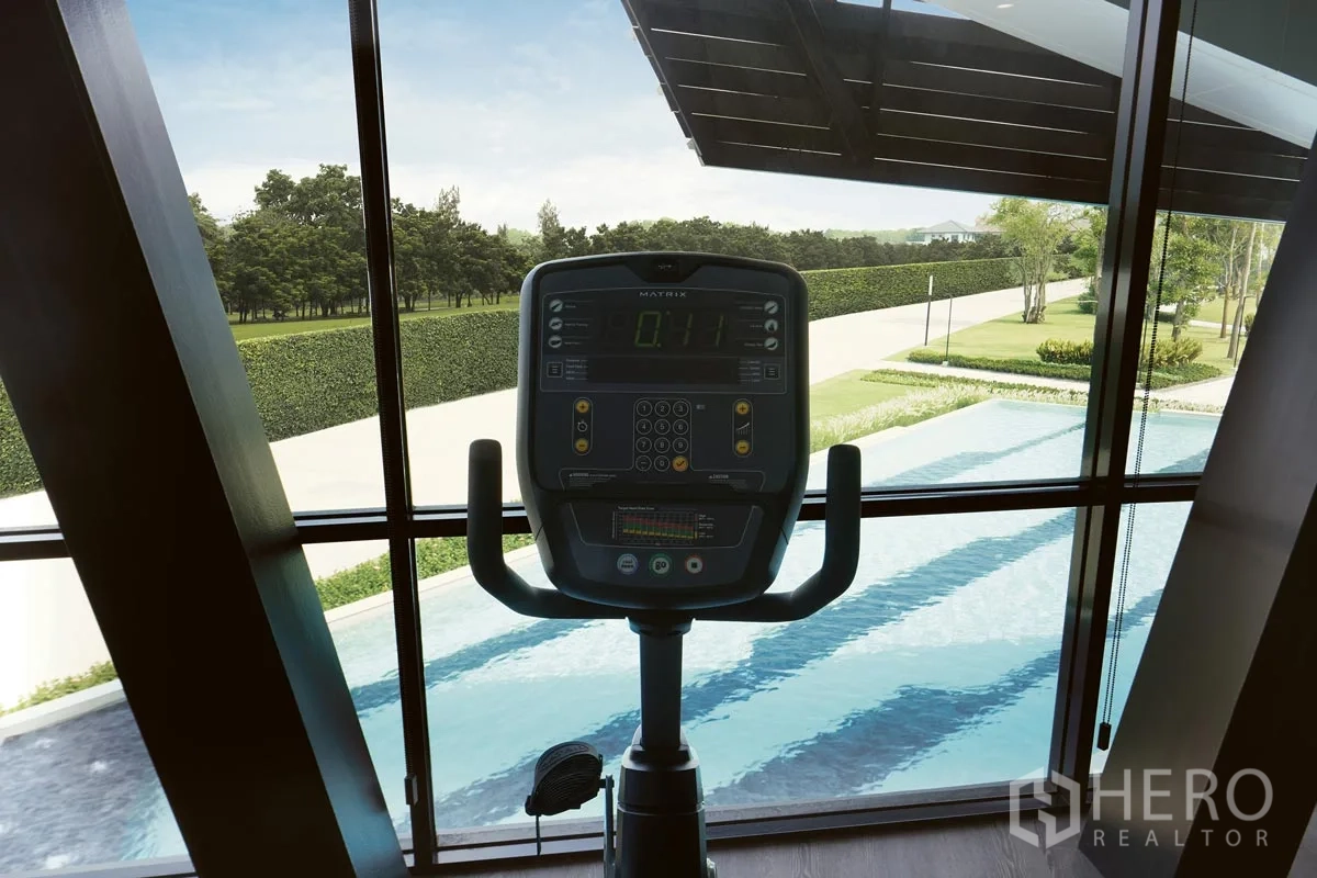 Detached House for rent or sale in Pathum Thani - Fitness room cardio machine overlooking the pool and gardens.