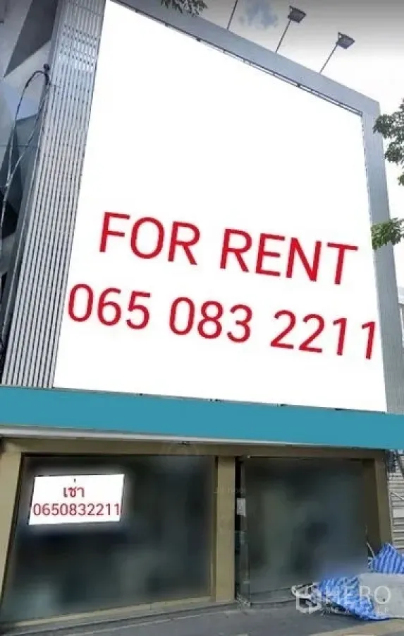Shophouse for rent in Khlong Toei, Bangkok - Modern shophouse façade with large billboard and glass frontage.