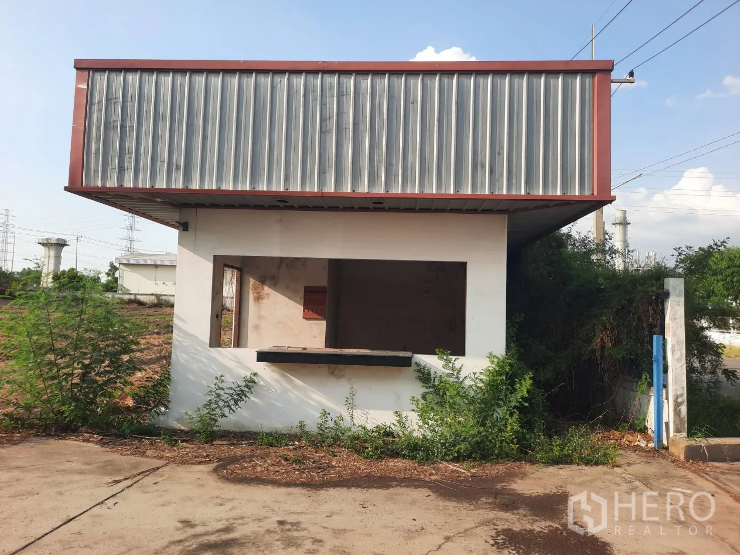 Factory for sale in Bang Pa-in, Phra Nakhon Si Ayutthaya - Security guard house at the site entrance beside greenery.