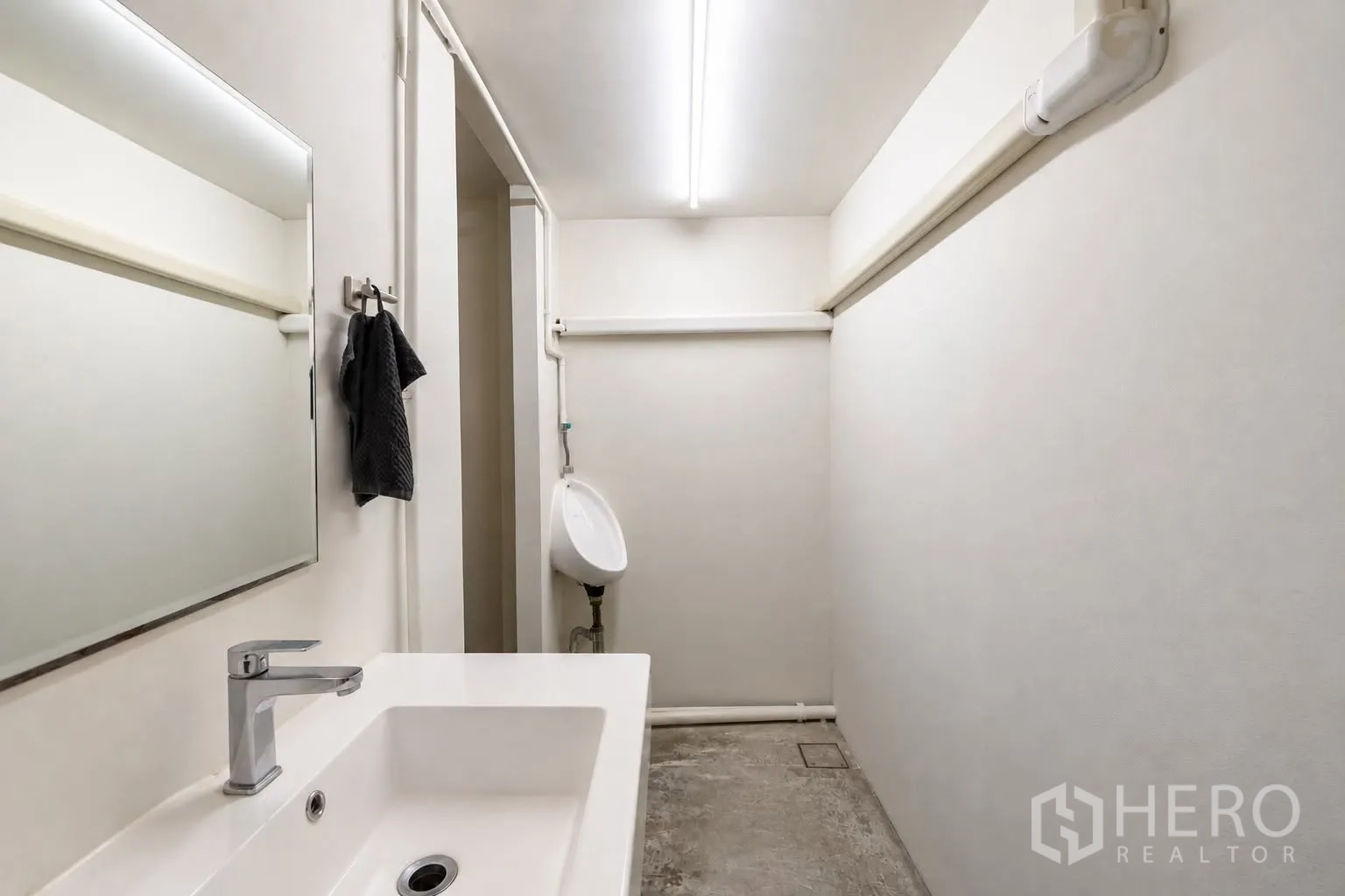 零售空间 for rent in Watthana, Bangkok - 整洁的卫生间，带洗手盆、镜子和小便池。