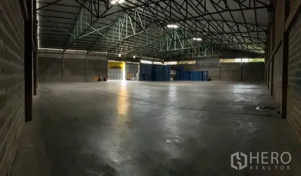 Warehouse for rent in Mueang Pathum Thani, Pathum Thani - Spacious warehouse interior featuring high steel-truss roof, polished concrete floor and clear open span.