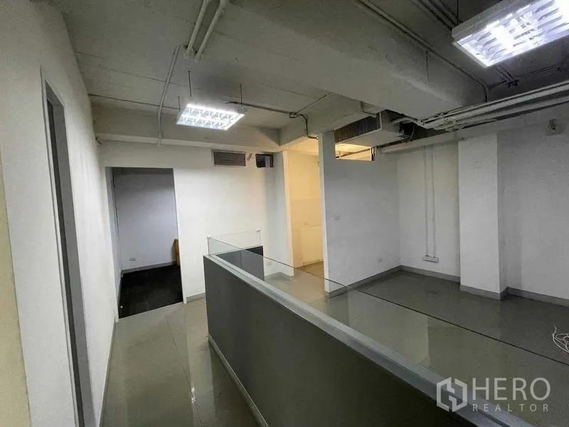 办公空间 出租在Ratchathewi, Bangkok - 紧凑的接待/走廊区，带内置柜台与明亮顶灯，管线外露。
