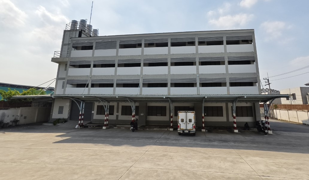 Warehouse for rent in Lat Krabang, Bangkok - Front elevation of a four-storey warehouse overlooking a wide concrete forecourt.