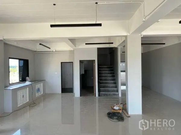 工厂 出售在Khlong Luang, Pathum Thani - 一层办公室大堂，瓷砖地面、楼梯与线性灯具。