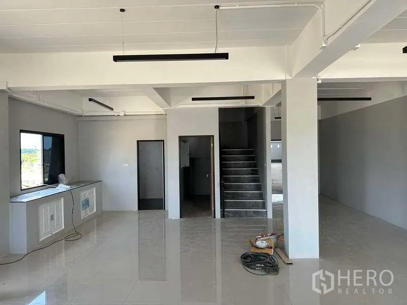 工厂 出售在Khlong Luang, Pathum Thani - 一层办公室大堂，瓷砖地面、楼梯与线性灯具。