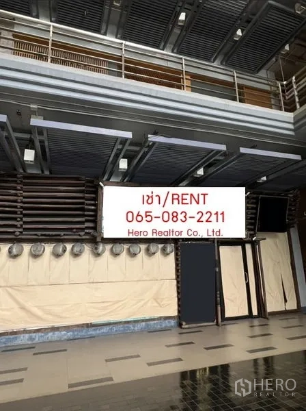 Retail Space for rent - Double-height retail storefront with louvered ceiling, glass entry and tiled floor in an indoor commercial area.