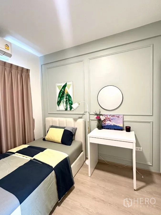Townhouse for rent in Prawet, Bangkok - Third bedroom corner with single bed, writing desk and decorative wall panels.